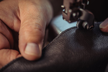 cropped view of cobbler sewing genuine leather on sewing machine - obrazy, fototapety, plakaty