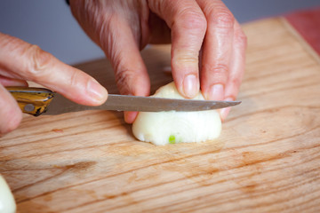 Man cutting fresh onion on a wooden board