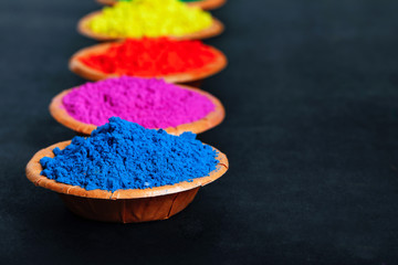 Indian Festival Holi , Colors in wooden bowl on dark background