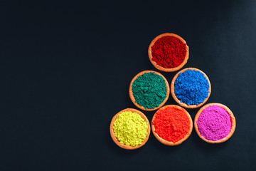 Fototapeta na wymiar Indian Festival Holi , Colors in wooden bowl on dark background