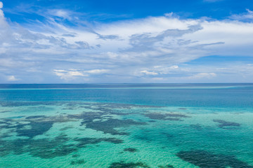 Fototapeta na wymiar Background image of the turquoise sea. Deep sea and corals. Top view of beautiful Caribbean Sea. Aerial drone shot of turquoise water - space for text. Aquamarine background