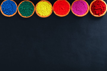 Obraz na płótnie Canvas Indian Festival Holi , Colors in wooden bowl on dark background