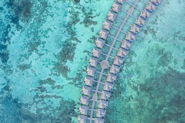 Aerial view of water villas and bungalow, blue sea with tropical lagoon background in Maldives. Luxury summer travel vacation concept, aerial landscape