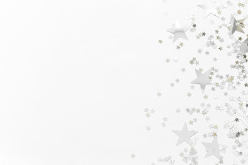 Silver confetti and stars and sparkles on a light background. Top view, flat lay. Copy text. holiday background. For Christmas, New Year, Valentine's Day