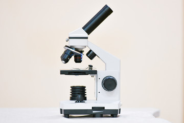 Microscope on a light background. Black and white microscope. Search for cancer cells. in the medical department of medicine. Salvation concept.