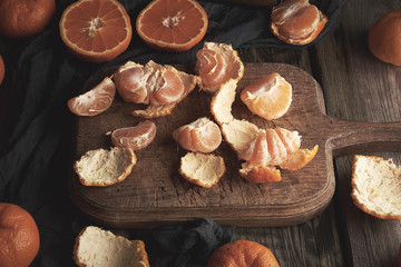 ripe round tangerines and cut in half on an old vintage cutting board