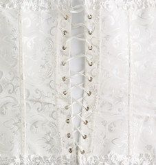 fragment of a white satin corset with lacing, back view, clothing item for brides
