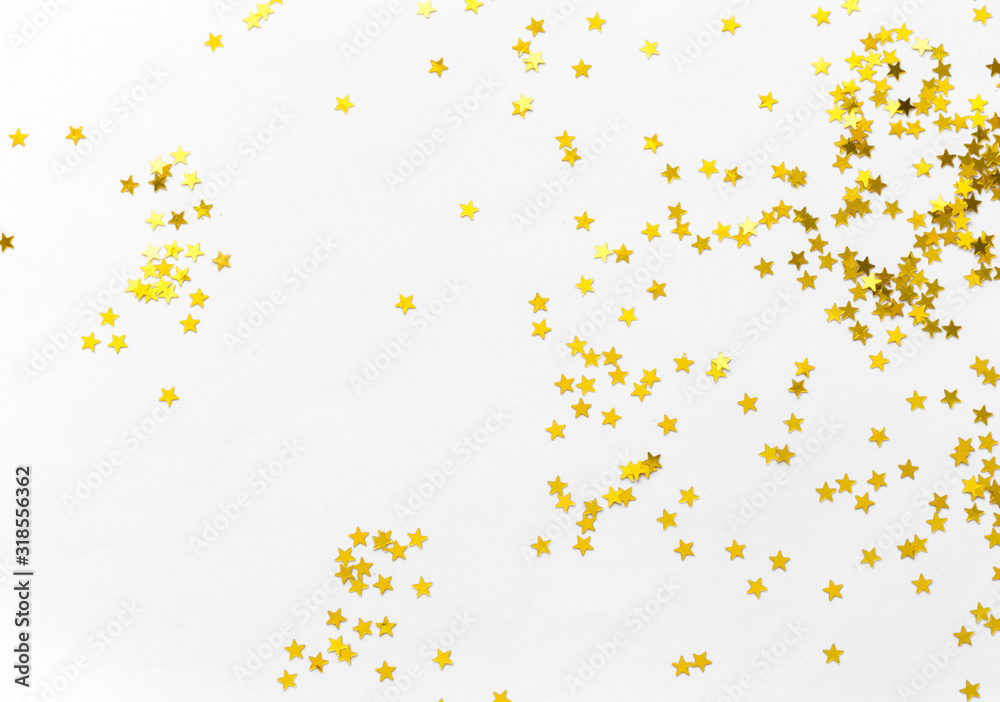 Wall mural Gold confetti and stars and sparkles on a light background. Top view, flat lay. Copy text. Bright and festive background. For Christmas, New Year, Mother's Day.