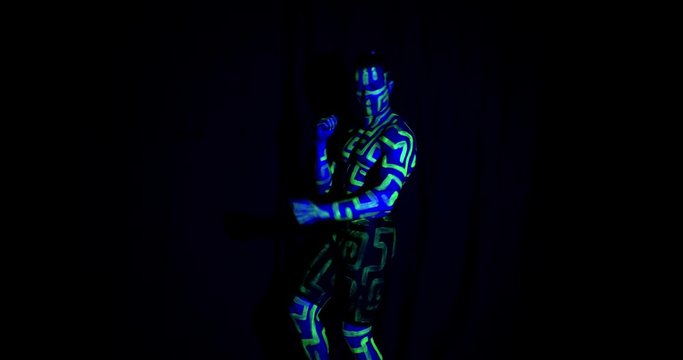 Dancing muscular man with ultraviolet body art and makeup, 4k