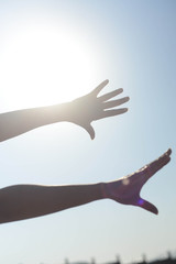 Young woman's hands reaching out towards the sky