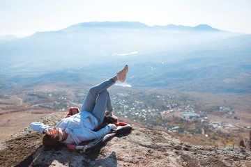 Young girl hipster takes a selfie on the background of mountains. Video communication. Nature background. Journey. A trip to the mountains.