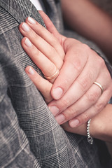 Br&auml;utigam h&auml;lt liebevoll die Hand seiner Braut an seine Brust. Beide tragen Ihren Ehering 