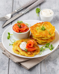 Fried potato pancakes with salmon and sour cream, fritter, roesti, golden crispy crust. Traditional delicious food