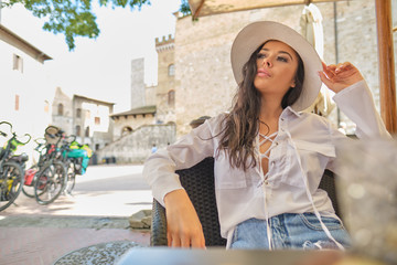 attractive woman tourist with hat in old italian town