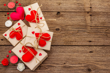 Zero waste gift concept. Valentine Day or Wedding eco friendly packaging. Festive boxes in craft paper with red felt hearts. Vintage wooden background