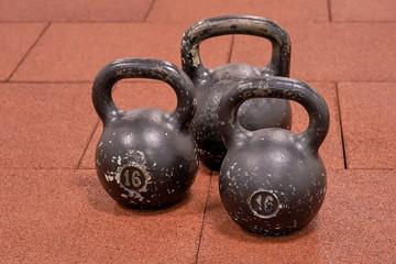 Fototapeta na wymiar three black iron kettlebell for weight training