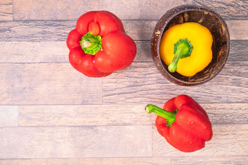 .Red and yellow bell peppers on wooden background.