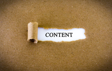 Content appearing behind torn brown paper