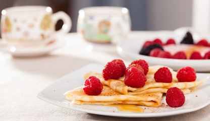breakfast of pancakes with fresh raspberries on table