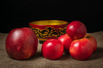 Fototapeta na wymiar Red apples lie on a burlap covered table.