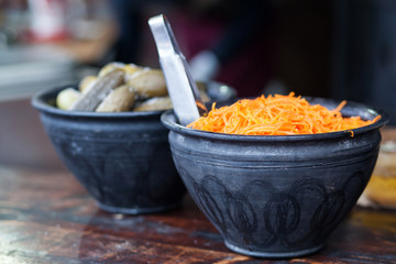 Carrot salad in a black ceramic bowl.Delicious and spicy carrot spaghetti with garlic and chilli.