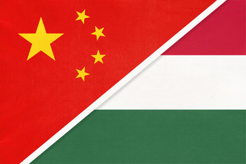 China or PRC vs Hungary national flag from textile. Relationship between asian and european countries.