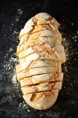 Beautiful sliced ​​bread on a dark background in flour. Bakery products. Top view, place for text. Assortment of bread.