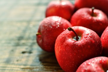 Red ripe apples on a dark wooden background. Delicious healthy fruits. Apples side view.