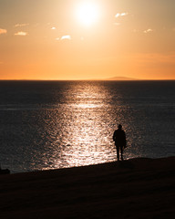 Silhouette of man looking at the sea