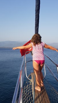 Rear View Of Girl Walking On Boat Deck