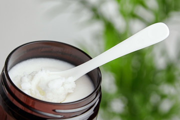Shea butter in jar with spoon, cosmetic product for moisturizing skin.