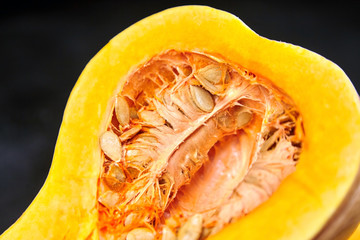 Butternut squash half with seeds, closeup. Pumpkin seeds. Cooking winter squash
