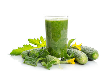  glass with green smoothie and  cucumbers, flowers, leaves isolated on white