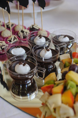 Close up of tray with lot delicious diversity pastry cakes tartlets and macaroon in a row. Fresh, multicoloured, colourful, green, yellow, white and pink sweet berry desserts, beautifully decorated