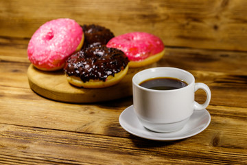 Cup of coffee and tasty donuts on a wooden table