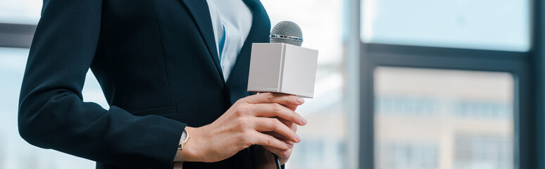 panoramic shot of journalist holding microphone