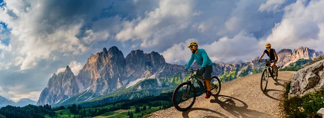 Foto op Plexiglas Bestsellers Sport Fietsen vrouw en man rijden op fietsen in de bergen van de Dolomieten andscape. Paar fietsen MTB enduro trail track. Buitensport activiteit.
