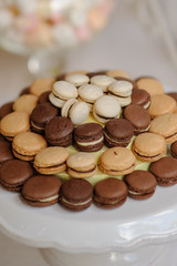 Close up of tray with lot delicious diversity pastry cakes tartlets and macaroon in a row. Fresh, multicoloured, colourful, green, yellow, white and pink sweet berry desserts, beautifully decorated