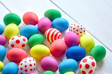 Easter eggs. Many colorful chicken eggs on white wooden background