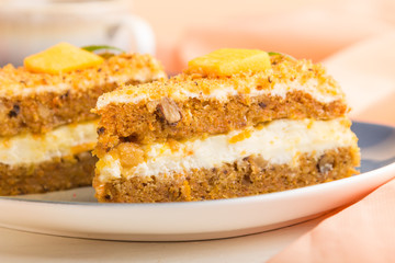 Homemade cake with persimmon and pumpkin and a cup of coffee on a white wooden background with orange textile. side view, selective focus.