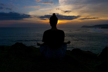 silhouette of young woman yoga at sunset