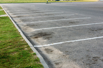 Obraz premium Empty outdoor dirty parking lot space marked with white lines.