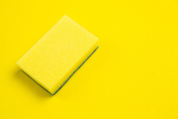 Yellow dishwasher sponge on a yellow background