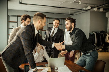 two leaders of diverse business companies shaking hands in office, at the end of effective meeting. young men in formal wear isolated in modern boardroom. business people, success concept