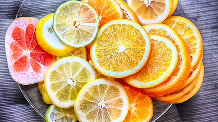 slices of citrus fruits of orange, lemon, grapefruit, lime on a plate, macro