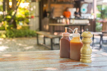 Bottles and spilled sauces of tomato ketchup, mustard and mayonnaise on teble