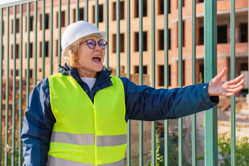 A woman Builder at a construction site inspects a house made of brick