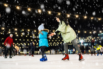 Street skating rink. Mom with daughter at the ice rink.