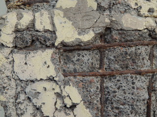 Gray concrete cracked rough wall with reinforcement, rough interesting texture