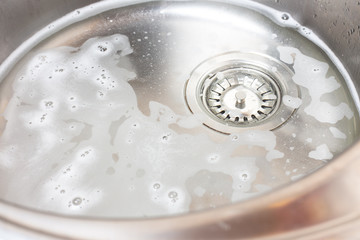Water with foam in a metal sink